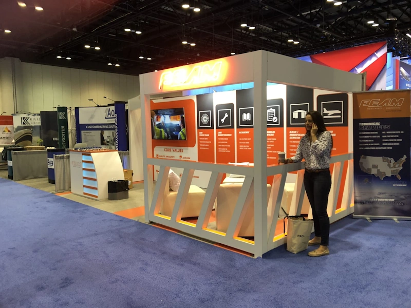 A woman in front of a booth at a Florida trade show displays.