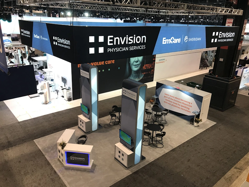 A custom trade show displays Fort Lauderdale for Envision Physician Services with large overhead displays and meeting area.